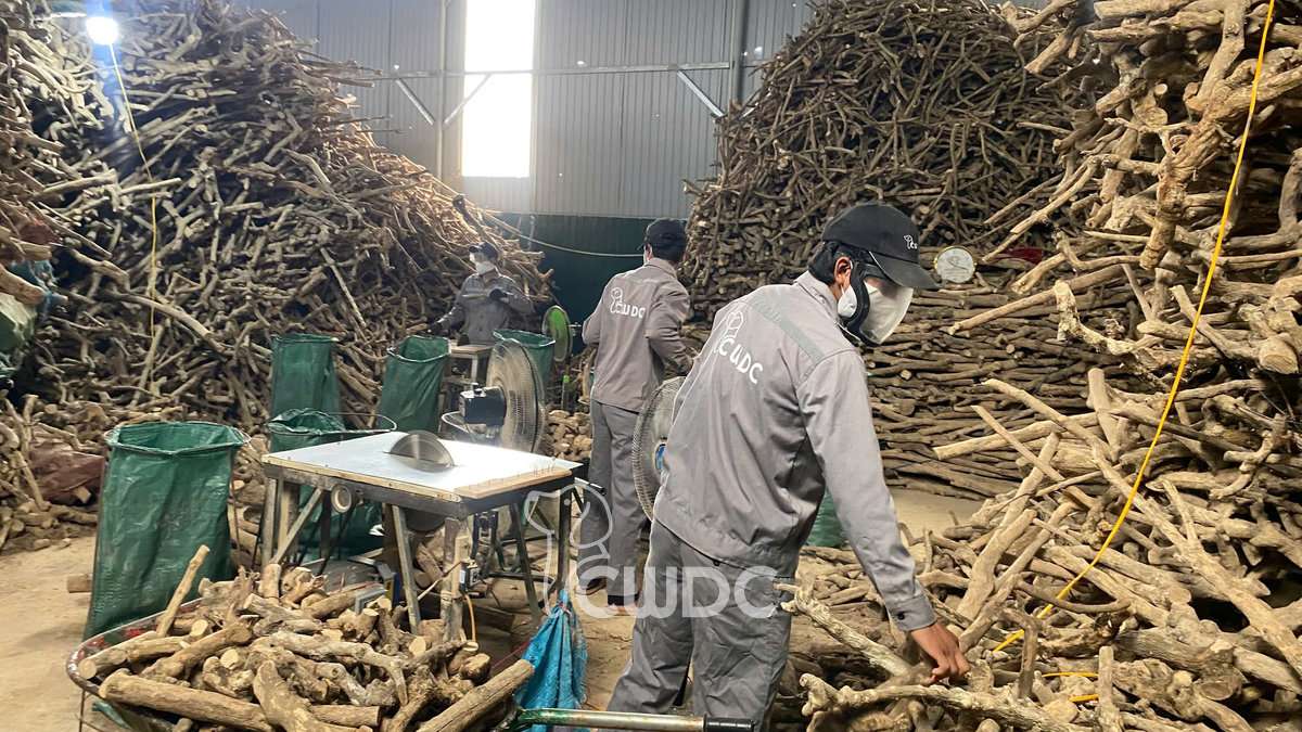 Multiple CWDC Vietnam workers wearing masks and protective gear at cutting stations with mesh dust collection bags